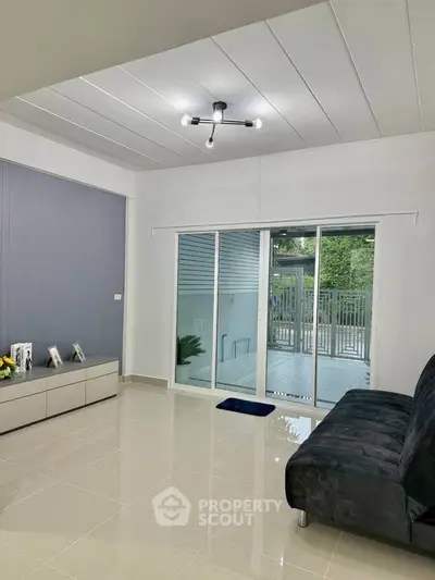 Modern living room with sleek design and sliding glass doors to patio.