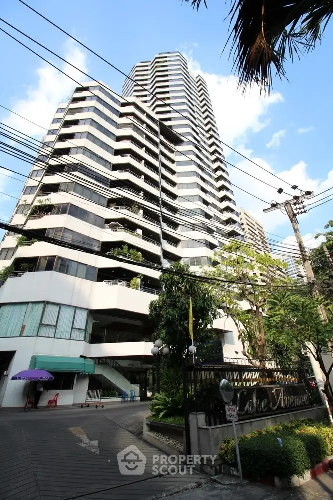 Stunning high-rise building with modern architecture and lush greenery in urban setting.