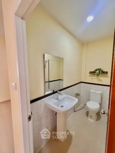 Modern bathroom with pedestal sink and toilet in a cozy real estate property.