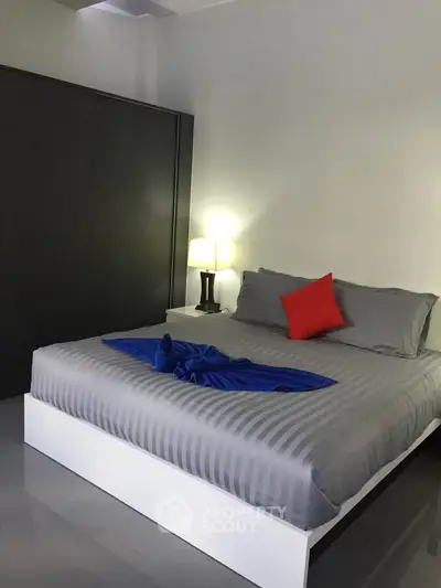 Modern bedroom with stylish decor and cozy ambiance, featuring a comfortable bed and elegant lighting.