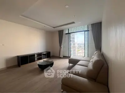 Spacious modern living room with large window and city view, featuring elegant furniture and minimalist design.