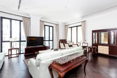 Spacious and elegant living room with classic furniture and large windows in a luxury apartment.