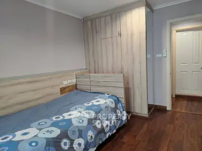 Cozy bedroom with wooden flooring and modern wardrobe design