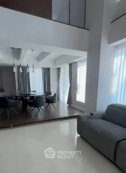 Spacious modern living room with elegant dining area and large windows