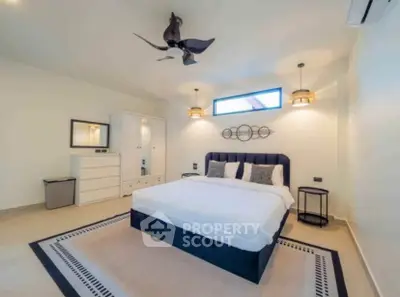 Spacious modern bedroom with elegant decor and ample natural light