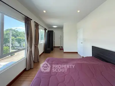 Spacious bedroom with large windows and scenic view, featuring modern decor and ample natural light.