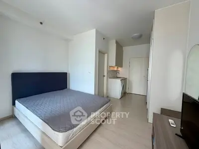 Modern studio apartment with cozy bedroom and compact kitchen area.