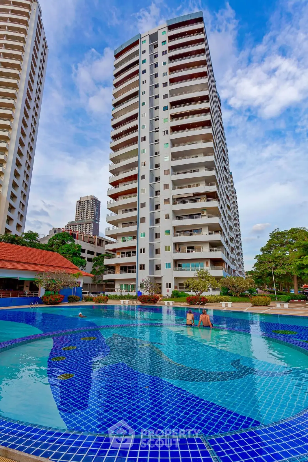 Stunning high-rise building with a luxurious pool and vibrant cityscape view.