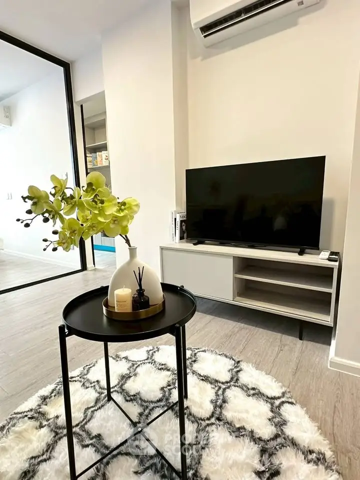 Modern living room with stylish decor and sleek TV setup, perfect for urban living.