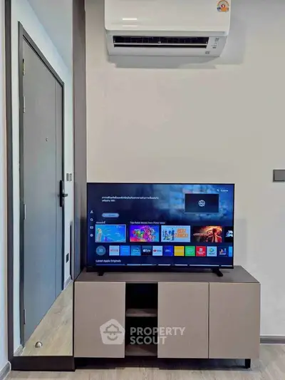 Modern living room with sleek TV setup and air conditioning unit, perfect for comfortable urban living.
