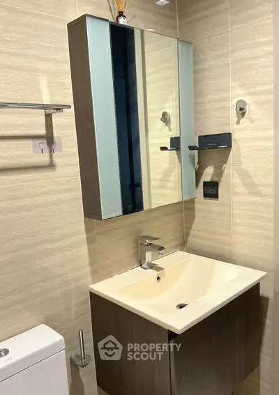 Modern bathroom with sleek vanity and mirror cabinet in contemporary design.