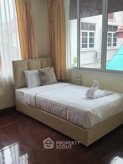 Cozy bedroom with large windows and elegant decor, perfect for relaxation and comfort.