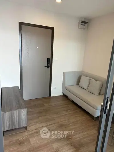 Cozy living room with modern sofa and wooden flooring, perfect for relaxation.