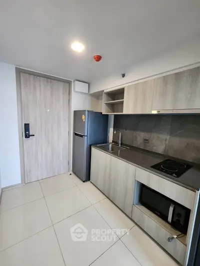 Modern kitchen with sleek cabinetry and built-in appliances in a compact layout.