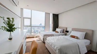 Spacious modern bedroom with twin beds and city view, perfect for urban living.