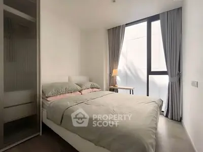 Modern bedroom with large window and minimalist decor in a stylish apartment.