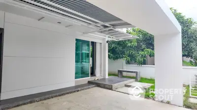 Modern home exterior with sleek design, featuring a spacious patio and lush greenery, perfect for outdoor relaxation.