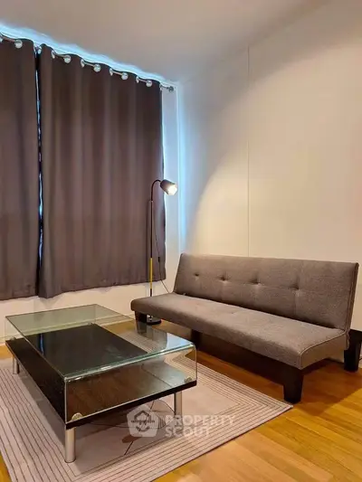 Modern living room with sleek glass coffee table and stylish sofa, perfect for urban living.