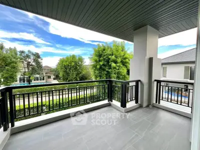 Spacious balcony with modern railing and scenic view in upscale neighborhood.