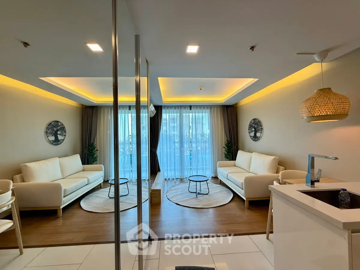 Modern living room with elegant decor and natural light, featuring cozy sofas and stylish lighting.