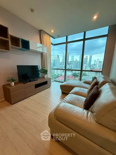 Modern living room with city view, large windows, and stylish furniture