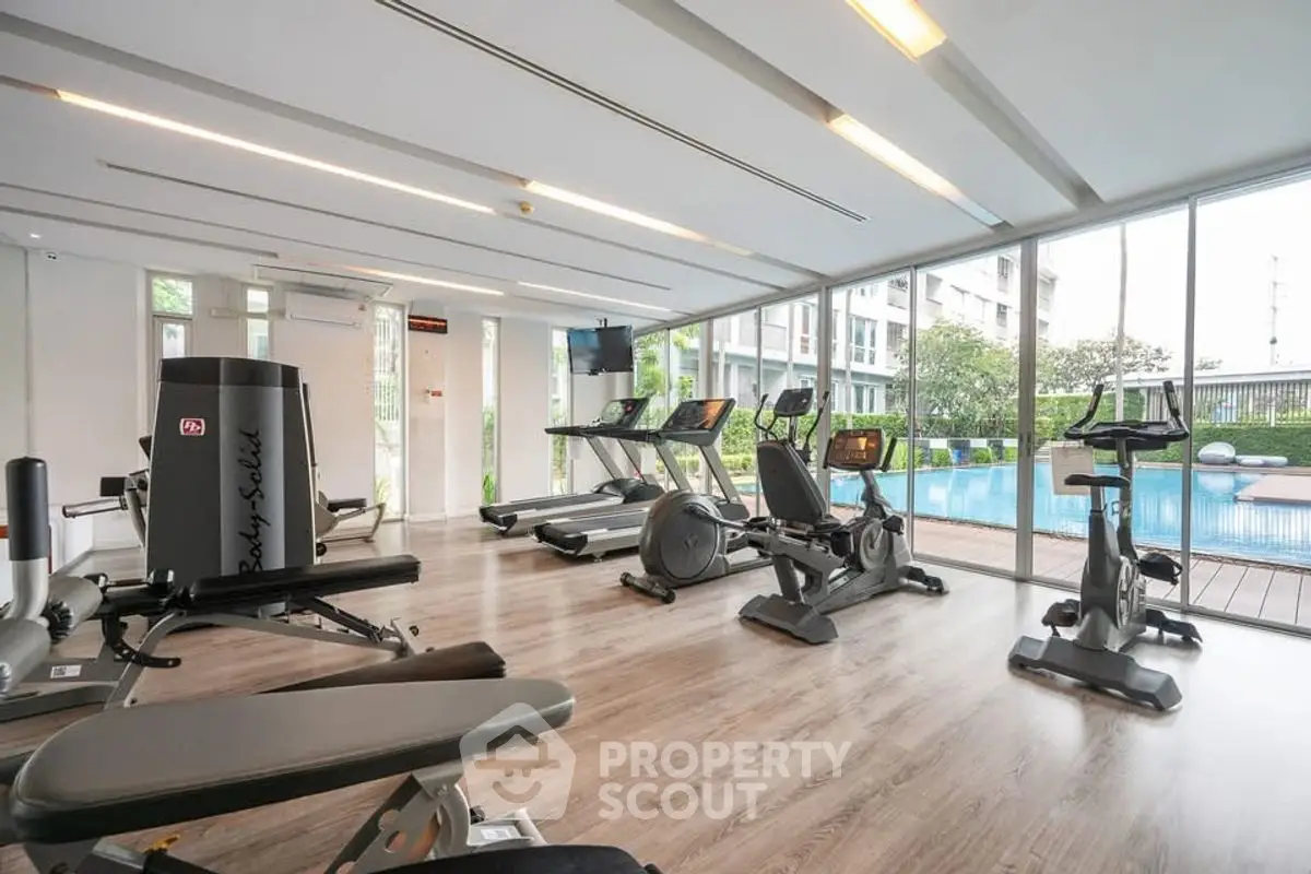 Modern gym with pool view in luxury residential building