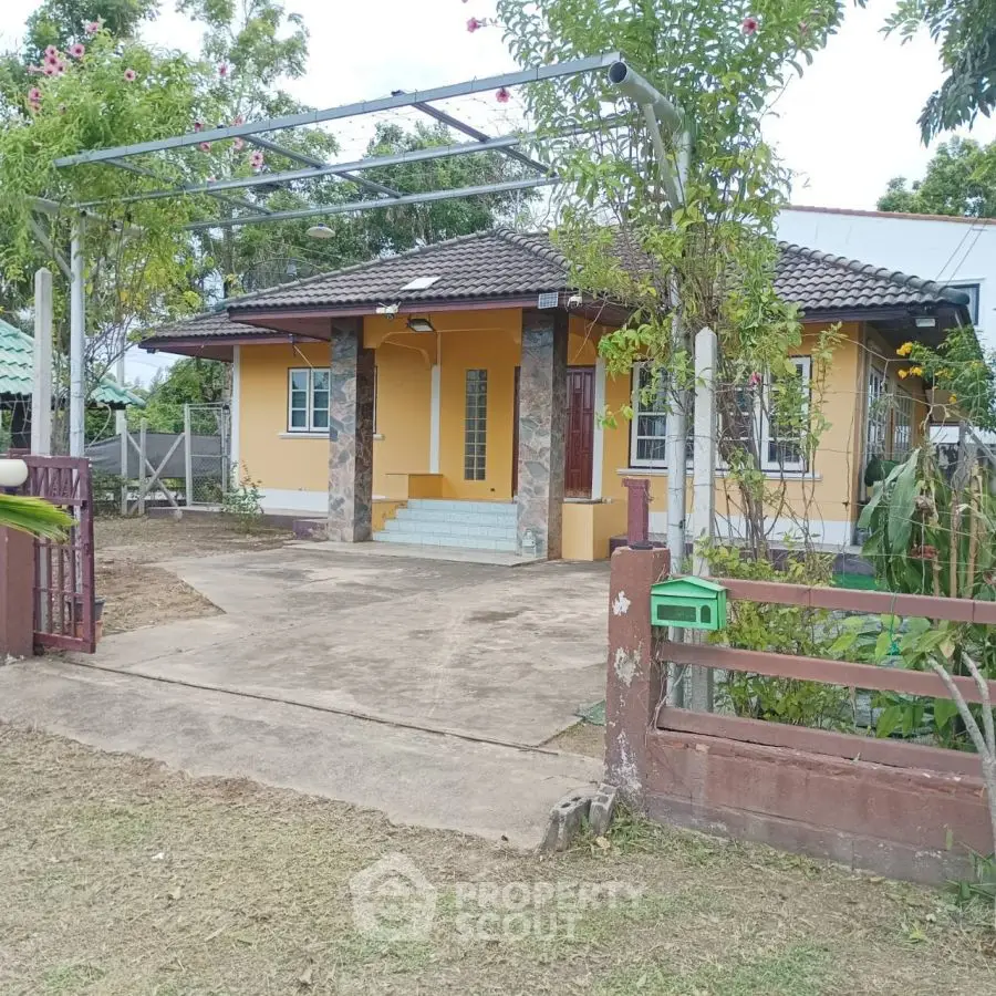 Charming single-story yellow house with tiled roof and spacious front yard.