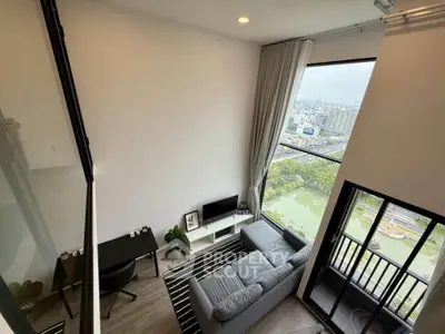 Modern living room with stunning city view and large windows in a high-rise apartment.