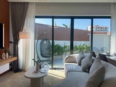 Modern living room with large glass doors opening to a private garden, featuring stylish furniture and decor.