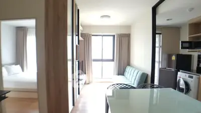 Modern apartment interior with open layout, featuring a cozy living area, kitchen, and bedroom.