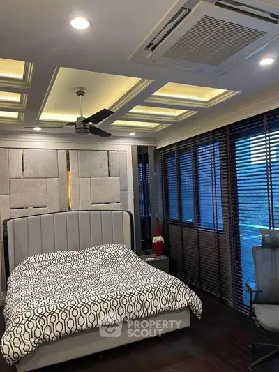 Luxurious bedroom with modern ceiling design and large windows