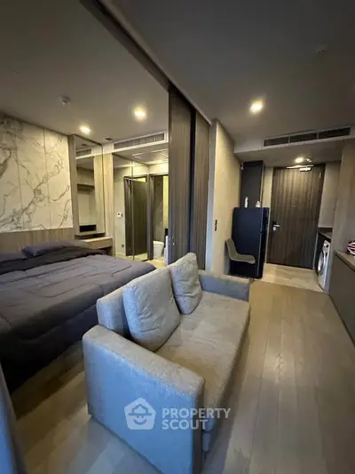 Modern studio apartment with open layout, featuring a cozy living area and stylish bedroom.