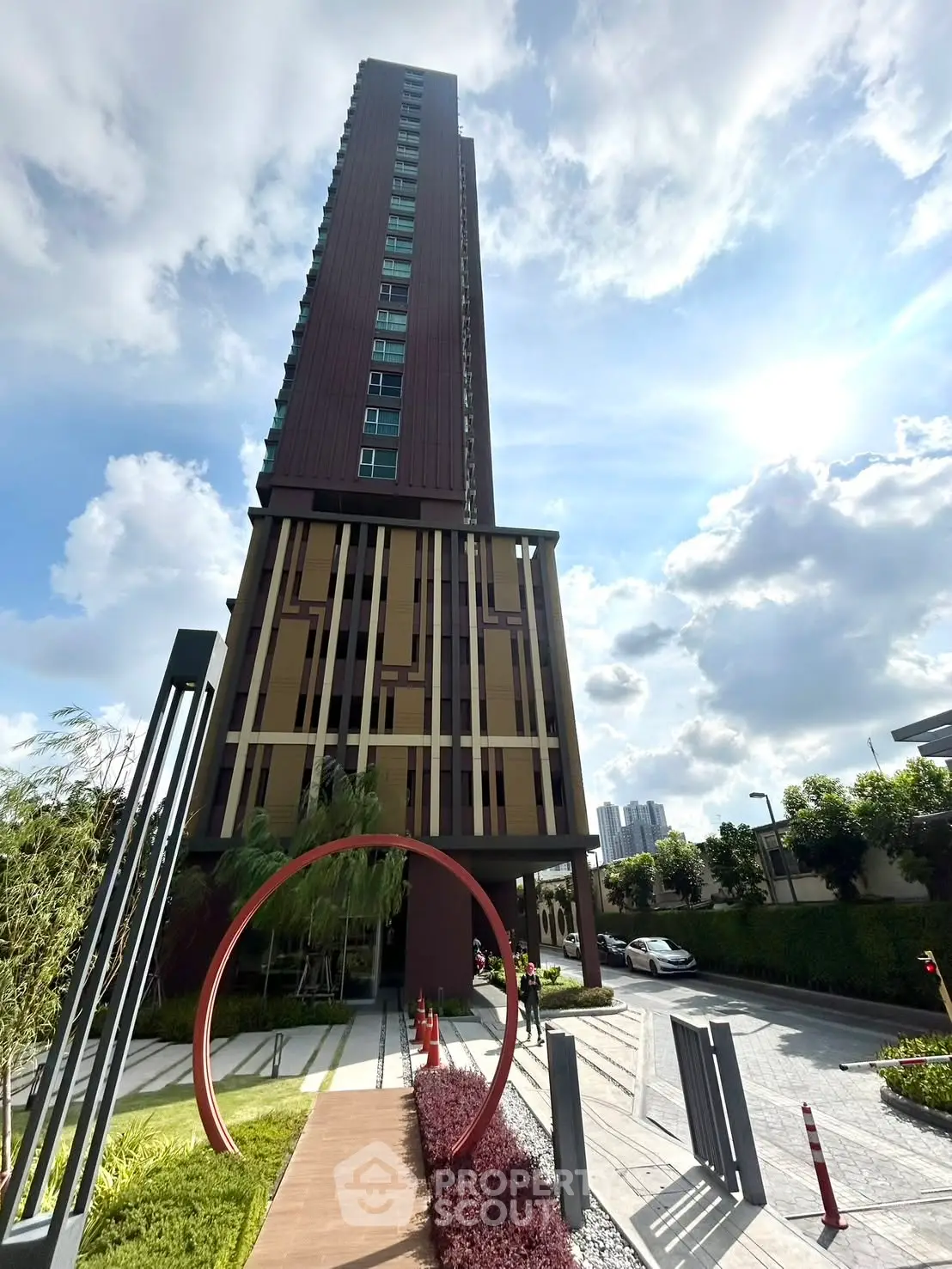 Stunning modern high-rise building with unique architectural design and lush landscaping, perfect for urban living.