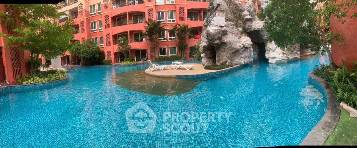 Luxurious resort-style pool with unique rock formations and lush greenery, perfect for relaxation.