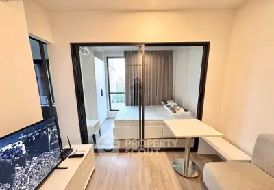 Modern studio apartment with glass partition, cozy living area, and stylish bedroom.