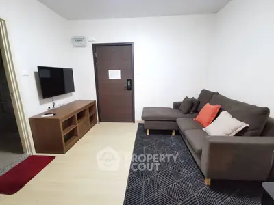 Modern living room with cozy sofa and wall-mounted TV in a stylish apartment.