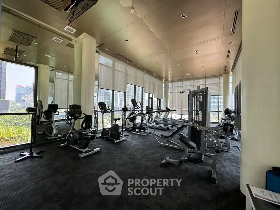 Spacious modern gym with city view in luxury residential building