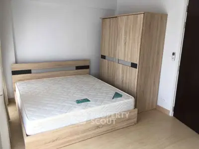 Modern bedroom with wooden furniture and comfortable mattress in a bright apartment.
