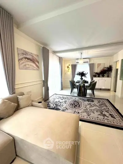 Elegant living room with plush sofa and stylish dining area, perfect for modern living.