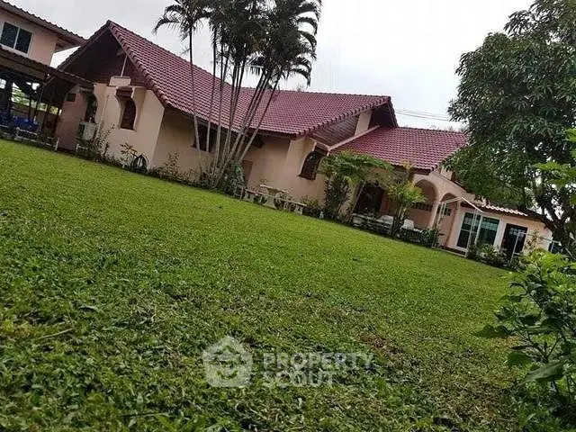 Charming single-story home with red-tiled roof and lush green lawn