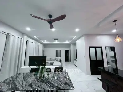 Spacious modern living room with elegant marble dining table and stylish ceiling fan.