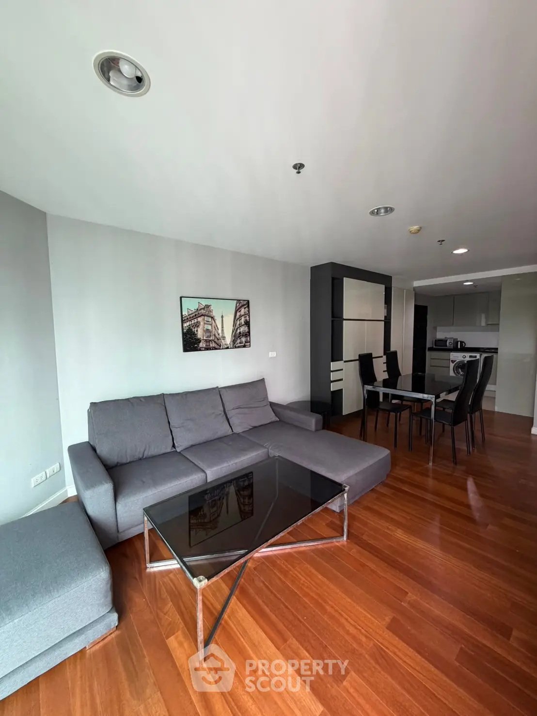 Modern living room with sleek furniture and open kitchen layout in a stylish apartment.