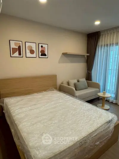Modern bedroom with cozy sofa and stylish decor in a well-lit apartment.