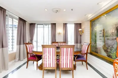 Elegant dining room with large windows and classic decor in a luxury apartment.