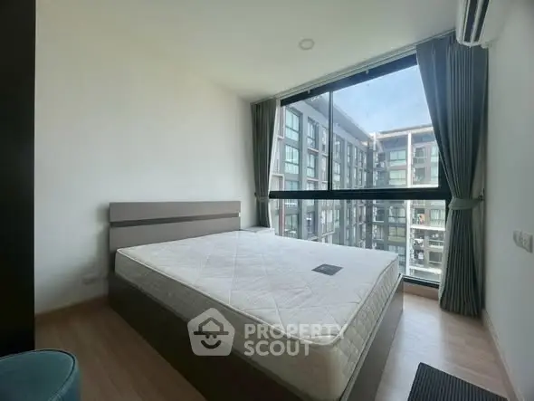 Modern bedroom with large window and city view in a stylish apartment