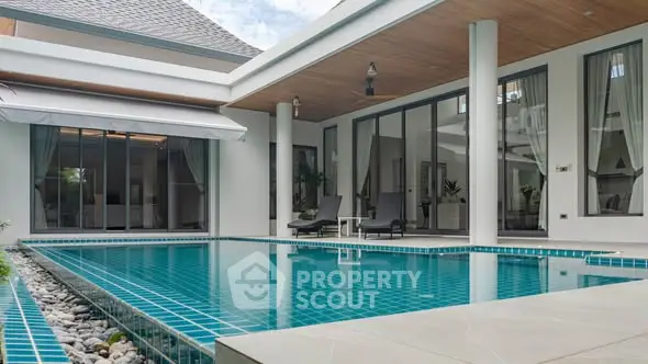 Luxurious modern villa with private pool and elegant outdoor seating area.