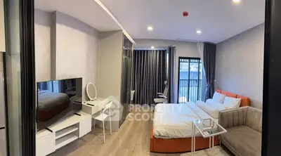 Modern studio apartment with stylish decor, featuring a cozy bed, sleek TV setup, and elegant lighting.