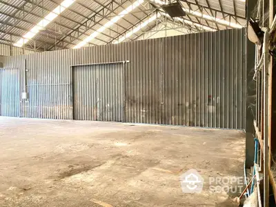 Spacious industrial warehouse with high ceilings and large metal doors