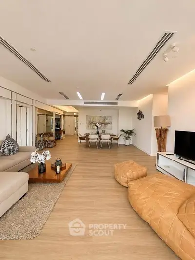 Spacious modern living room with elegant decor and open layout, featuring cozy seating and stylish dining area.