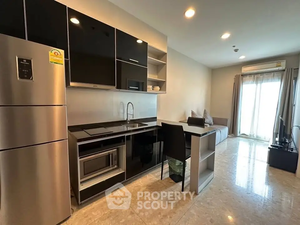 Modern open-layout kitchen with sleek appliances and cozy living area in a stylish apartment.